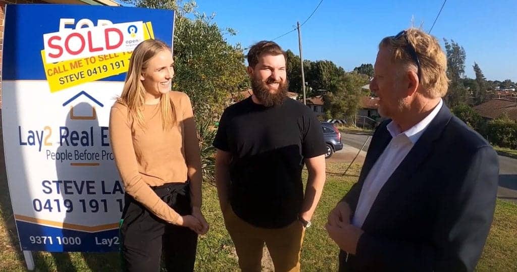 Picture of buyers standing in front of a for sale - sold sign on a property in bayswater WA