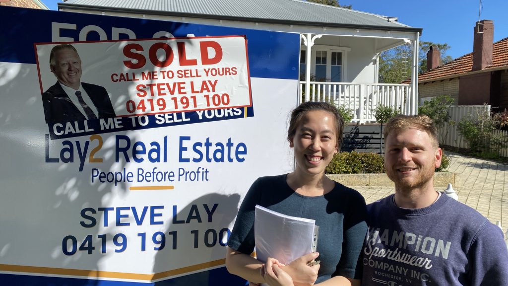 Happy Bayswater Home Buyers in front of sold sign
